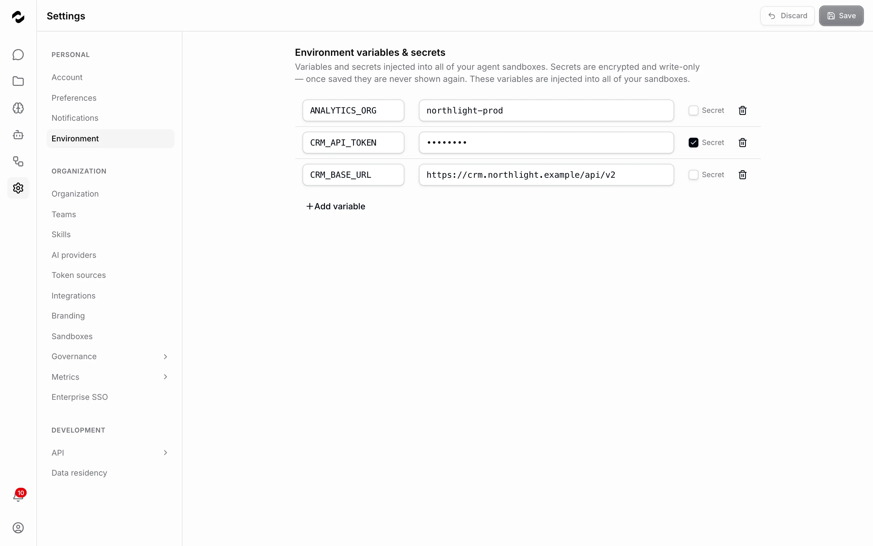 Die Umgebungs-Einstellungsseite listet drei gespeicherte Einträge — ANALYTICS_ORG und CRM_BASE_URL mit offen sichtbaren Werten und CRM_API_TOKEN als Punkte maskiert, mit angehaktem Kästchen Geheim — über der Aktion Variable hinzufügen.